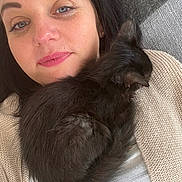 Kitty a rejoint le concours — aidez-le/la à gagner de superbes lots ! woman, kitten, black_cat, pet, snuggling, close_up, indoor, cozy, portrait, face, fur, sleeping_cat, eyebrows, lipstick, nose_ring, hair, sweater, fabric, relaxation, cuddle