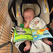 Jason joined the competition — help win amazing prizes! baby, infant, sleeping, shopping_cart, car_seat, blanket, book, toy, bib, thumb_sucking, portrait, indoors, store, retail, safety_labels, face, feet, cozy, colorful, parenting