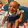 Zuri joined the competition — help win amazing prizes! baby, smiling, denim_dress, headband, pacifier, silver_boots, pillow, blanket, bed, indoor, child, happy, cute, infant, clothing, person, portrait, sitting, home, accessory