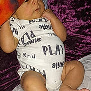 Dariely'S is registered to the contest to win money with this photo: baby, infant, pillow, onesie, clothing, bed, blanket, foot, hand, skin, face, leg, laying, cute, child, sleepwear, resting, indoors, soft, relaxing