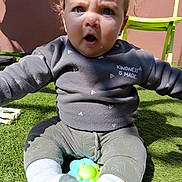 Théo a rejoint le concours — aidez-le/la à gagner de superbes lots ! baby, child, grass, outdoor, toy, sitting, sweater, expression, face, person, green_chair, sunlight, playtime, cute, young_child, casual_clothing, daylight, curious, open_mouth, nature