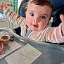 Théo participe au concours pour gagner de l'argent avec cette photo : baby, high_chair, toy, drawing, child, curious, indoor, face, arms, wide_eyes, clothing, table, seat, expression, person, furniture, play, colorful, closeup, portrait
