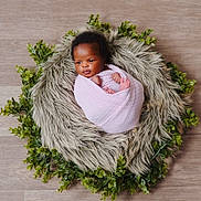 Destiny is registered to the contest to win money with this photo: baby, blanket, curly_hair, cute, earrings, face, fur, greenery, indoor, infant, leaves, nest, newborn, peaceful, portrait, skin, small_feet, soft_texture, wood_floor, wrapped