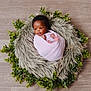 baby, blanket, curly_hair, cute, earrings, face, fur, greenery, indoor, infant, leaves, nest, newborn, peaceful, portrait, skin, small_feet, soft_texture, wood_floor, wrapped