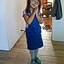 child, girl, glasses, blue_dress, socks, indoor, wooden_floor, vacuum_cleaner, door, curtain, smiling, posing, long_hair, casual_clothing, home, floor_tiles, wall, cozy, happy, young