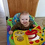 Jenny participe au concours pour gagner de l'argent avec cette photo : baby, child, smile, walker, toy, indoor, floor, wooden_floor, wooden_wall, colorful, happy, person, clothing, play, infant, seat, face, expression, young, cute