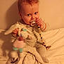 Jenny a rejoint le concours — aidez-le/la à gagner de superbes lots ! baby, pacifier, toy, blanket, mesh_background, infant, cute, child, sitting, indoor, soft_lighting, playful, hand, clothing, expression, face, young_child, comfort, warm, portrait