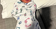 Keisha is registered to the contest to win money with this photo: newborn, baby, sleeping, blanket, footprint_pattern, hat, bow, pillow, bed, resting, infant, cute, cozy, wrapped, indoor, soft, peaceful, child, portrait, warm