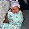 Keisha is registered to the contest to win money with this photo: newborn, baby, sleeping, swaddled, blanket, watermelon_pattern, hat, striped, bows, hand, adult, cozy, indoor, portrait, cute, infant, resting, soft, toddler, person