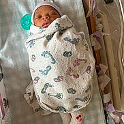 Keisha joined the competition — help win amazing prizes! newborn, baby, swaddled, blanket, footprints, sleeping, pacifier, socks, cherry, infant, bed, nursery, soft, cozy, child, person, cute, resting, wrapped, peaceful