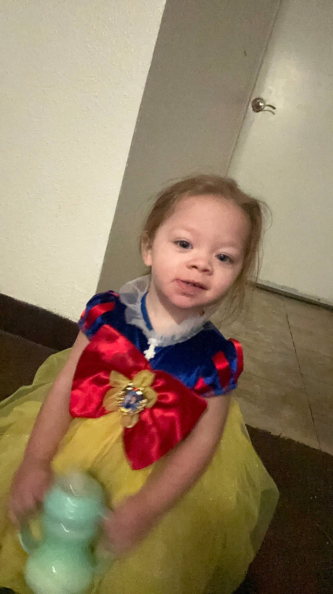 Harleigh is registered to the contest to win money with this photo: baby, baby_toddler_clothing, cheek, child, comfort, electric_blue, flooring, fun, happy, nose, pattern, person, room, scarf, sitting, skin, sleeve, toddler, wood