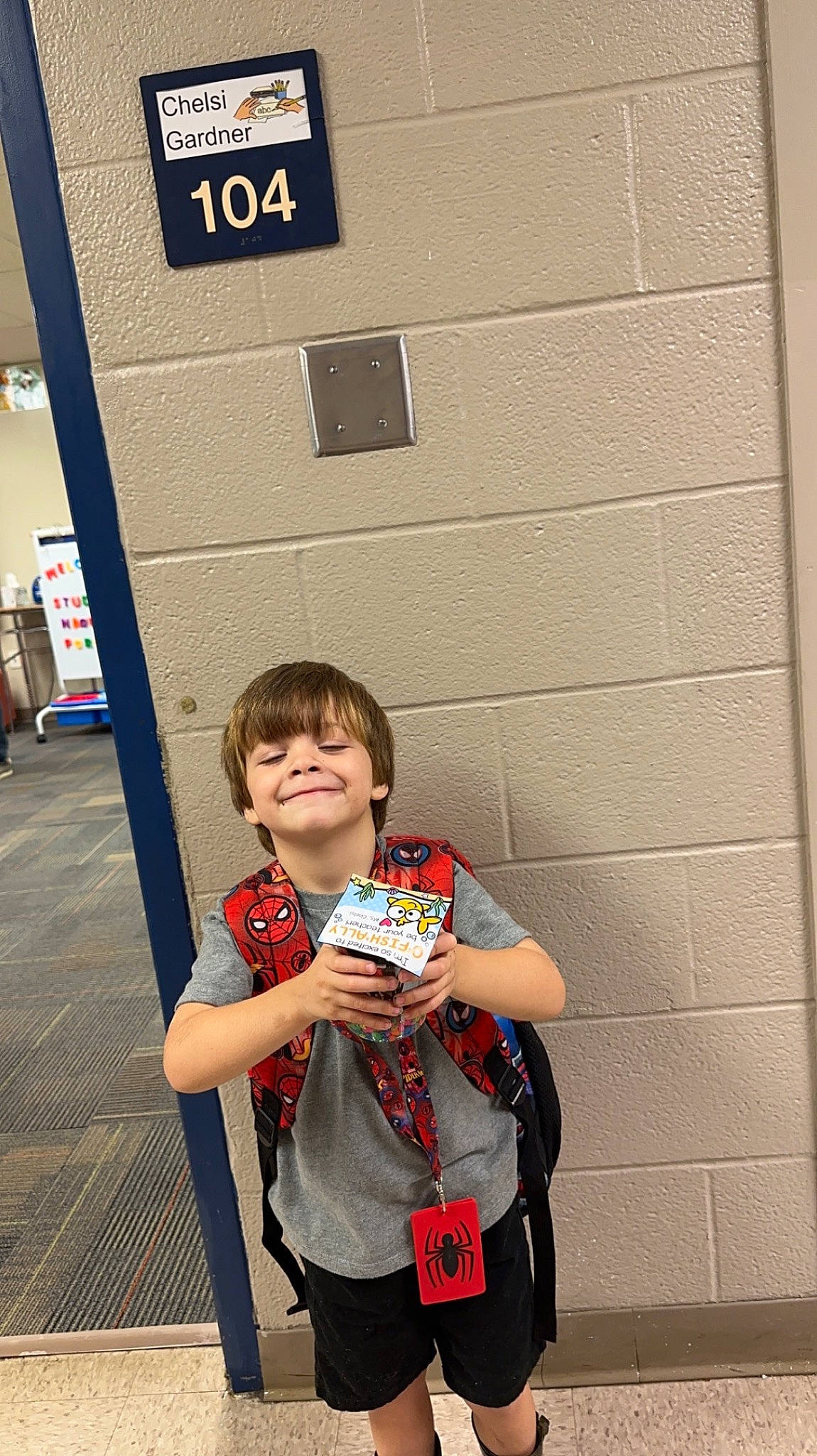 Grayson is registered to the contest to win money with this photo: bag, child, electric_blue, event, fashion_accessory, flooring, fun, gesture, happy, joy, logo, luggage_and_bags, person, room, sleeve, smile, t_shirt, travel, waist