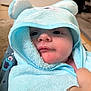 baby, child, towel, blue, hood, face, hand, cute, cozy, soft, plush, indoor, person, infant, wrapped, closeup, skin, expression, apparel, comfort
