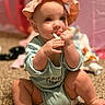 Raelynn joined the competition — help win amazing prizes! baby, child, infant, hat, onesie, carpet, chewing, sitting, cute, indoor, soft_focus, toy, blanket, peach_color, green_clothing, skin, hand, face, expression, young