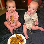 Raelynn joined the competition — help win amazing prizes! baby, babies, child, children, cookie, chocolate_chip_cookie, food, messy, indoor, sitting, pink_clothing, cream_clothing, cute, face, hands, plate, floor, playful, happy, infant