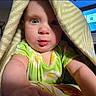 baby, blanket, child, face, green_clothing, indoor, lamp, living_room, person, portrait, reaching, tent, television, toddler, cute, curious, expression, furniture, home, cozy