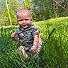 baby, child, grass, outdoor, nature, sunny, greenery, trees, blue_sky, smiling, stuffed_animal, backpack, cute, infant, playing, sitting, daylight, happy, person, portrait