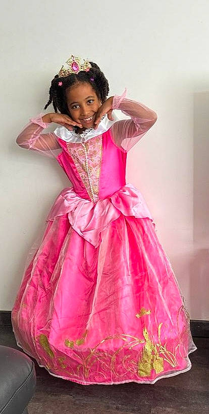 Aby participe au concours pour gagner de l'argent avec cette photo : baby_toddler_clothing, clothing, day_dress, dress, embellishment, face, fashion_design, formal_wear, hair, happy, head, joy, magenta, one_piece_garment, outerwear, person, pink, purple, shoulder, skin