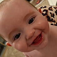 Violet joined the competition — help win amazing prizes! baby, smile, close_up, face, indoor, child, happy, skin, expression, cheeks, teeth, person, blanket, furniture, shelf, leopard_print, cute, infant, tongue, portrait