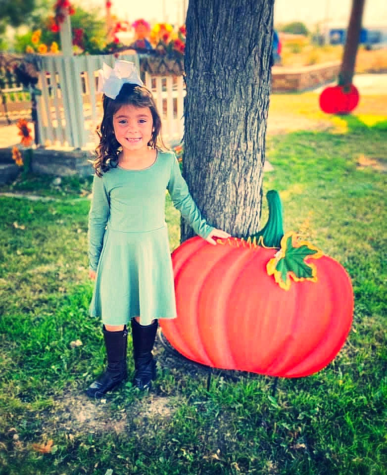 Avi is registered to the contest to win money with this photo: autumn, calabaza, child, dress, family, fruit, grass, green, happy, joy, orange, person, photography, plant, pumpkin, sitting, smile, toddler, tree, vegetable