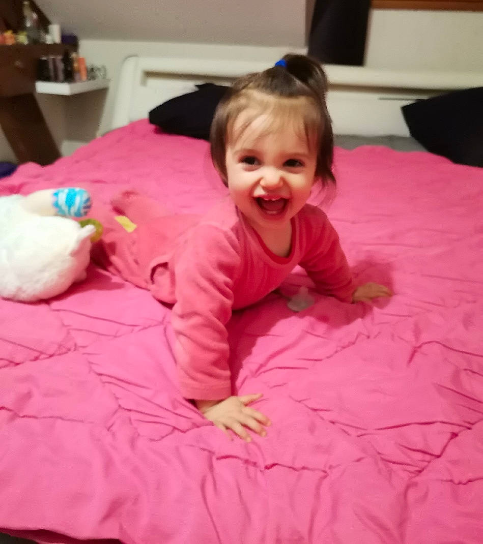 Hannah a rejoint le concours — aidez-le/la à gagner de superbes lots ! baby, baby_toddler_clothing, bed, bedding, cheek, child, comfort, flooring, fun, happy, joy, linens, magenta, mammal, mouth, person, pink, purple, skin, smile