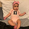 baby, infant, child, pink_onesie, headband, bow, cute, sitting, bed, pillow, indoors, skin, feet, hands, expression, portrait, toddler, clothing, person, young_child