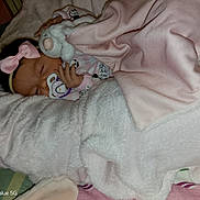 Amelia joined the competition — help win amazing prizes! baby, infant, sleeping, blanket, bed, pacifier, plush_toy, stuffed_animal, pink, white, bow, clothing, nursery, cozy, portrait, indoor, bedding, cuddled, resting, photograph