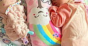 Adalynn is registered to the contest to win money with this photo: baby, blanket, child, cloud, cozy, cute, floor, floral_pattern, indoors, infant, pajamas, peaceful, pillow, pink, plush_toy, rainbow, resting, sleeping, soft_toy, wooden_floor