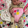 Adalynn is registered to the contest to win money with this photo: animal_print, baby, baby_seat, blanket, child, colorful, cute, floor, green, heart_shape, indoor, infant, mickey_mouse, pajamas, pink, polka_dots, toy, white, wooden_floor, yellow