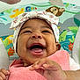 baby, smiling, headwrap, pink_towel, hand, happy, face, infant, closeup, cute, child, joy, colorful_background, animal_print, seated, portrait, skin, expression, playful, toddler