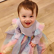 Malaya joined the competition — help win amazing prizes! baby, child, clothing, colorful, cute, dress, floor, happy, indoors, long_sleeve, person, playful, portrait, pretty, sitting, smiling, sparkles, toddler, wooden_floor, young_child