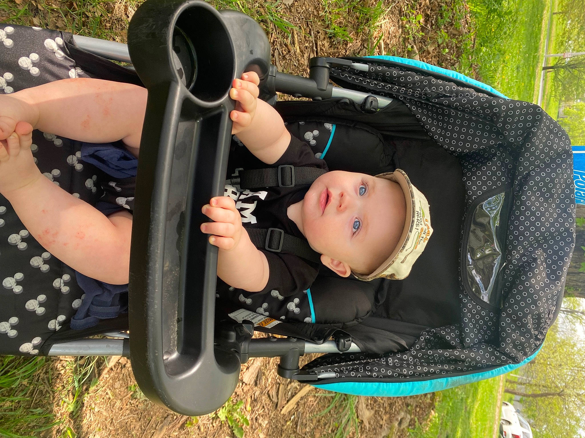 Kingsley is registered to the contest to win money with this photo: auto_part, baby, baby_carriage, baby_products, baby_toddler_clothing, chair, child, fun, grass, leisure, person, personal_protective_equipment, plant, play, recreation, sitting, tire, toddler, tree, vehicle