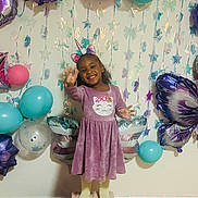 Xianah is registered to the contest to win money with this photo: child, girl, birthday, balloons, unicorn_headband, purple_dress, cat_design, smiling, celebration, party, decorations, stars, butterfly_balloon, flower_balloon, standing, happy, indoor, posing, festive, colorful