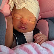 Raelynn is registered to the contest to win money with this photo: newborn, baby, sleeping, car_seat, blanket, pacifier, headband, pink, soft_toys, infant, child, peaceful, cute, indoors, toddler, resting, closeup, portrait, warm_light, cozy