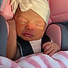 newborn, baby, sleeping, car_seat, blanket, pacifier, headband, pink, soft_toys, infant, child, peaceful, cute, indoors, toddler, resting, closeup, portrait, warm_light, cozy