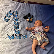 Cyana a rejoint le concours — aidez-le/la à gagner de superbes lots ! baby, infant, bed, butterfly, blue, dress, sunglasses, flower, bottle, pattern, lying_down, cute, skin, hand, foot, fabric, indoor, decor, arrangement, peaceful