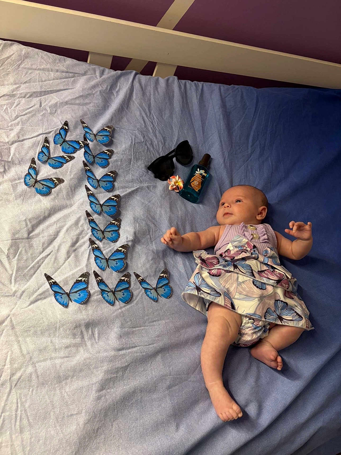 Cyana a rejoint le concours — aidez-le/la à gagner de superbes lots ! baby, infant, bed, butterfly, blue, dress, sunglasses, flower, bottle, pattern, lying_down, cute, skin, hand, foot, fabric, indoor, decor, arrangement, peaceful