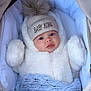 baby, infant, hat, pom_pom, winter_clothing, blanket, stroller, blue, white, cute, face, child, warm, soft_texture, portrait, clothing, outdoor_gear, newborn, cozy, sleeping_bag