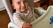Kimiya joined the competition — help win amazing prizes! baby, high_chair, smile, face, food_crumbs, indoor, child, person, seat, table, wood_floor, wooden_furniture, clothing, long_sleeve, happy, cute, feeding, home, infant, playful