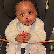 Khadidja Ifeoma participe au concours pour gagner de l'argent avec cette photo : baby, car_seat, infant, white_clothing, pacifier, straps, wide_eyes, curious_expression, child, toddler, seatbelt, sitting, indoor, cute, young_child, person, portrait, warm_clothing, hands, face