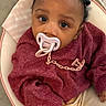 Khadidja Ifeoma a rejoint le concours — aidez-le/la à gagner de superbes lots ! baby, infant, pacifier, braids, sweater, pants, baby_seat, cushion, warning_label, child, cute, indoors, person, face, looking_up, comfortable, cozy, skin, hand, expression