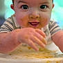 baby, cheeks, child, close_up, clothing, cute, face, feeding, food, hand, happy, high_chair, indoors, infant, meal, messy, smile, striped_shirt, table, tongue