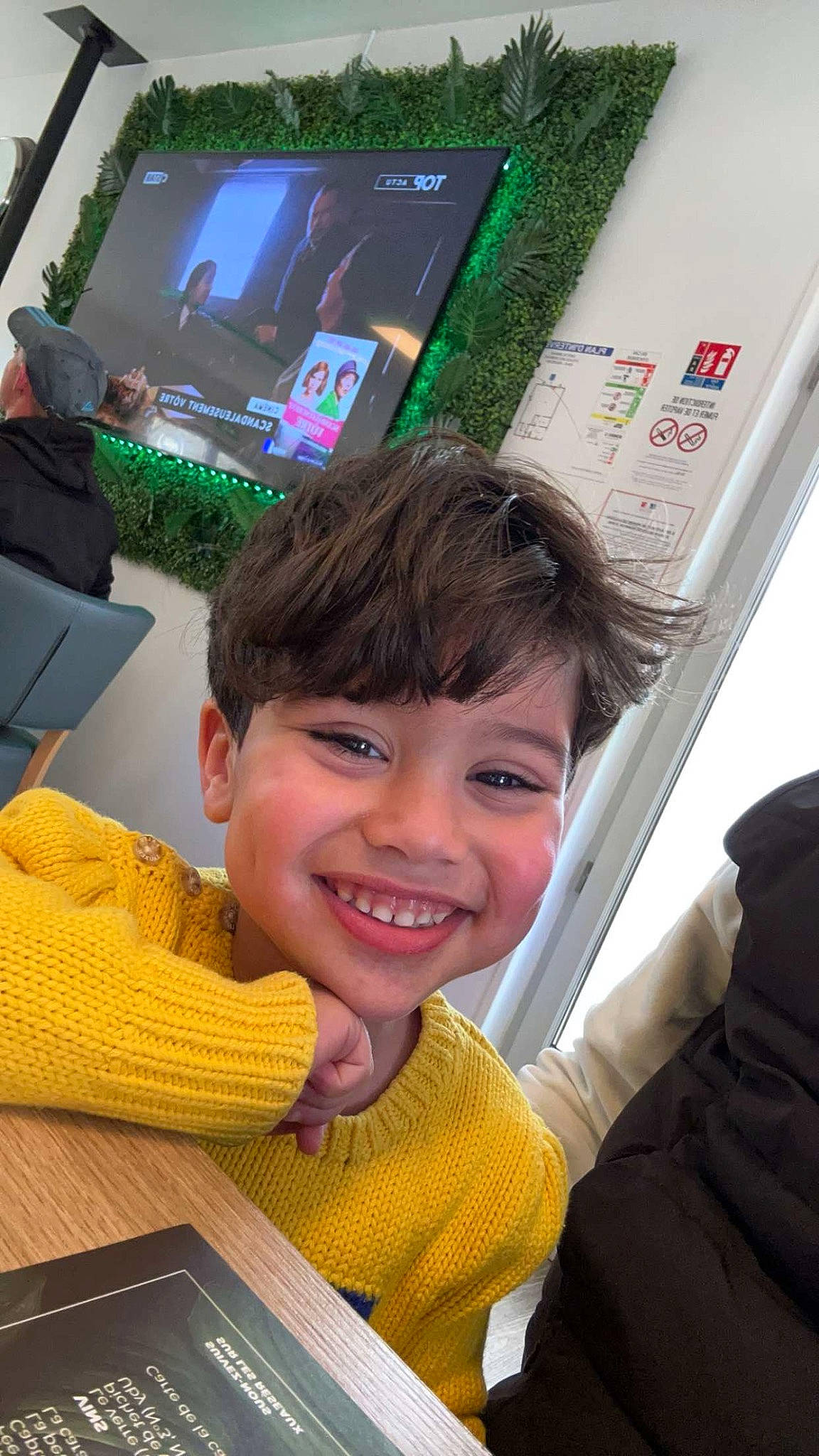 Fadi a rejoint le concours — aidez-le/la à gagner de superbes lots ! child, display_device, electronic_device, finger, flooring, fun, gadget, green, happy, joy, leisure, person, room, smile, t_shirt, technology, television, television_set, thumb, toddler