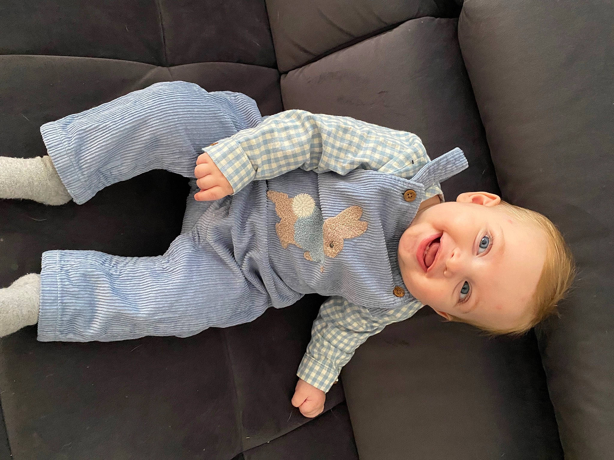 Léo a rejoint le concours — aidez-le/la à gagner de superbes lots ! baby, baby_toddler_clothing, child, comfort, couch, elbow, flooring, gesture, glasses, human_leg, joy, knee, linens, pattern, person, sitting, sleeve, smile, studio_couch, thigh