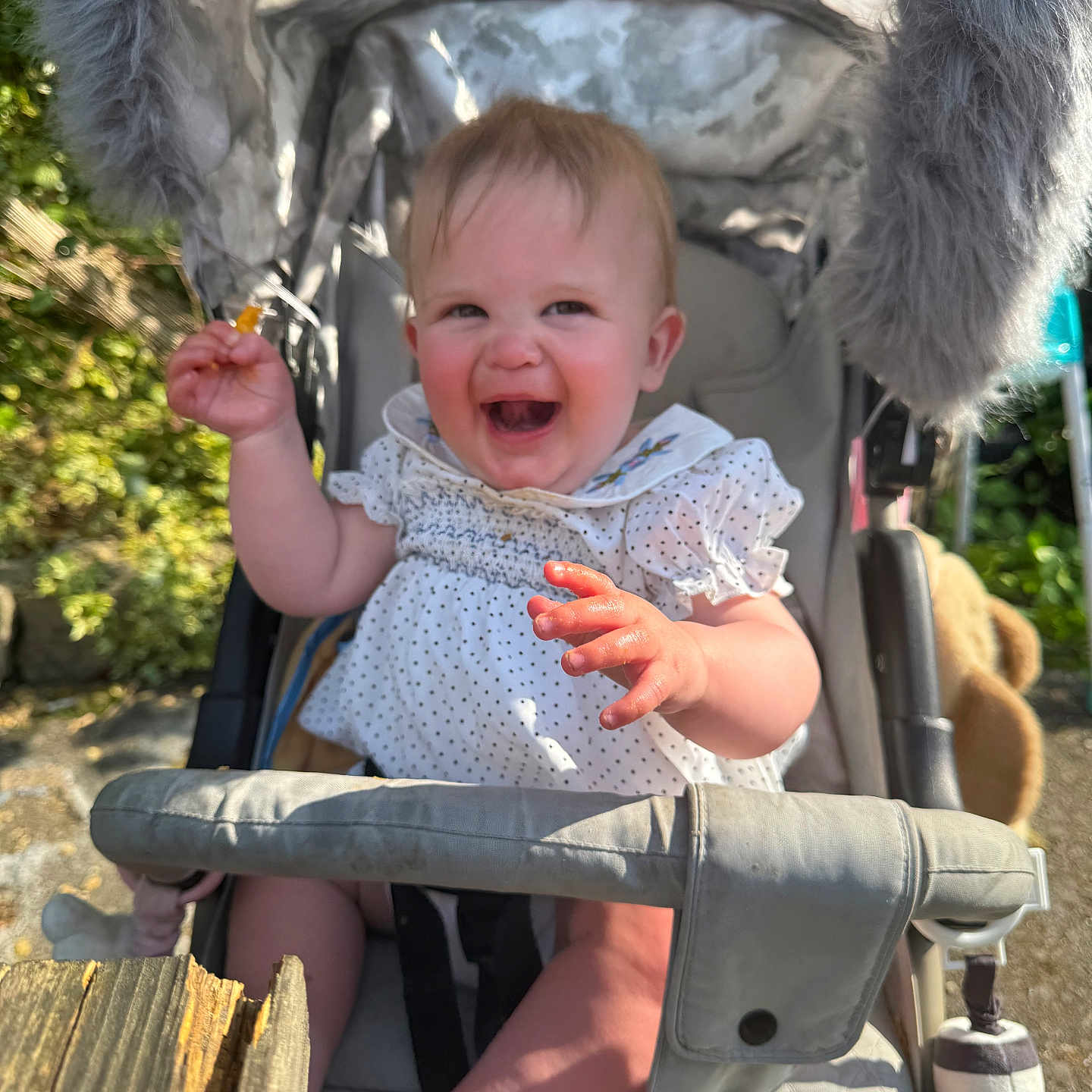 Eevee-Rae is registered to the contest to win money with this photo: accessories, baby, bench, bodypart, clothing, dress, face, finger, furniture, hand, happy, head, laughing, mouth, person, photography, portrait, sitting, strap, stroller