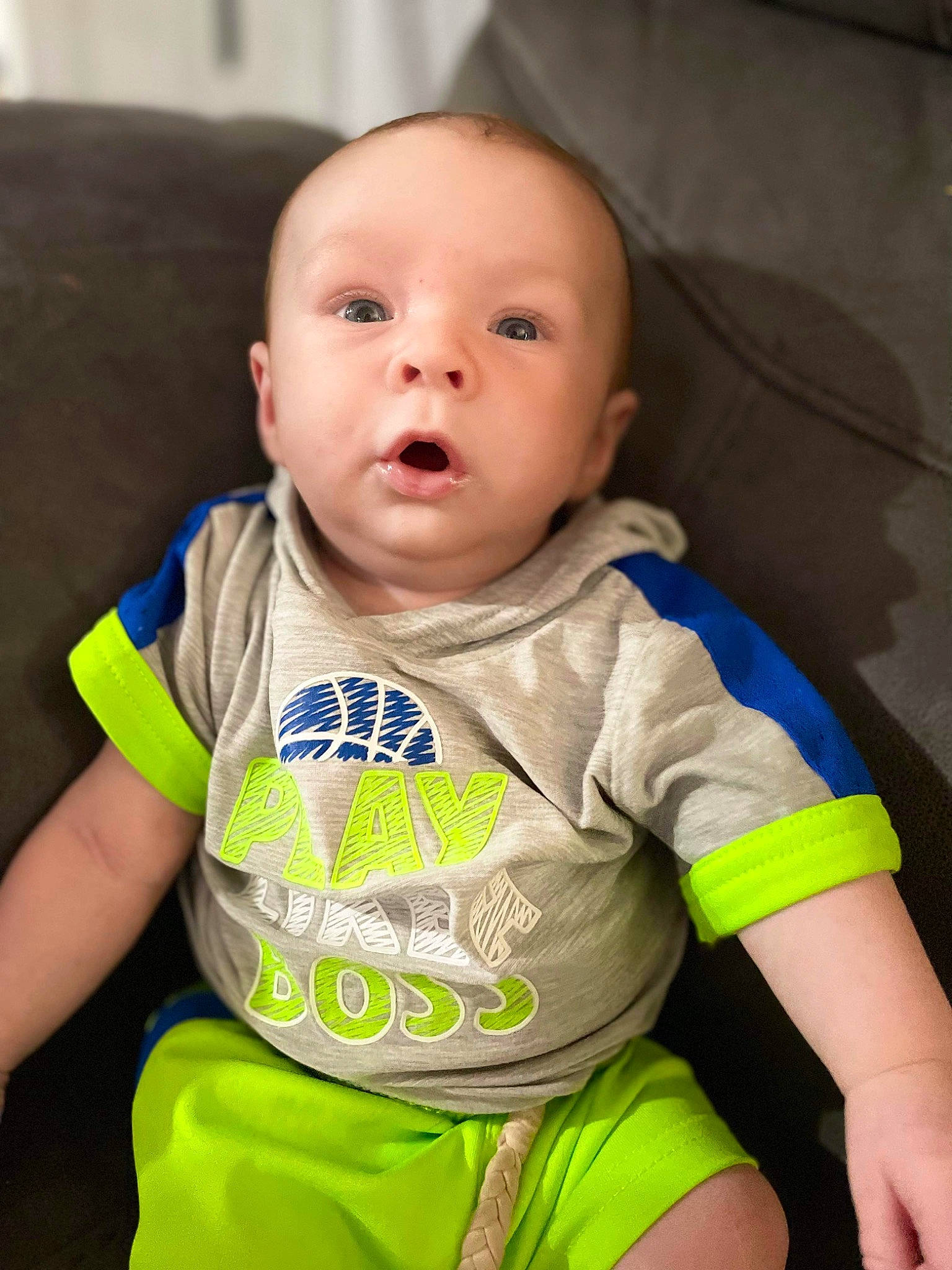 Thatcher is registered to the contest to win money with this photo: baby, baby_products, baby_toddler_clothing, cheek, child, collar, comfort, electric_blue, eyebrow, fun, happy, iris, nose, person, personal_protective_equipment, sitting, skin, sleeve, smile, t_shirt