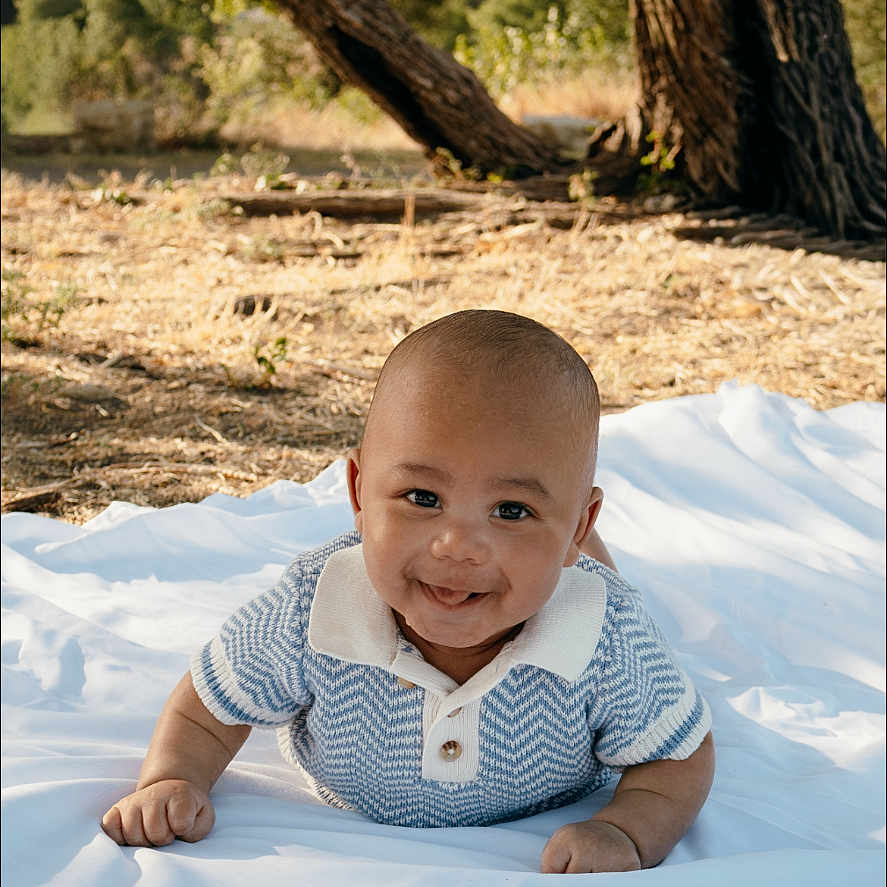 Kyrie joined the competition — help win amazing prizes! baby, smiling, outdoor, blanket, tree, grass, sunlight, child, nature, happy, toddler, portrait, shirt, head, face, skin, crawling, daylight, young, person