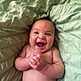 baby, smiling, diaper, hands, face, skin, lying_down, blanket, infant, joyful, cute, child, happy, expression, closeup, human, portrait, newborn, indoors, soft