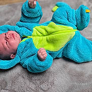Lyam a rejoint le concours — aidez-le/la à gagner de superbes lots ! adorable, baby, blue_onesie, child, cozy, crawling, cute, dinosaur_costume, expression, hooded_outfit, indoor, infant, infant_face, lying_down, plush_blanket, portrait, sleepwear, small_hands, soft_texture, warm_clothing