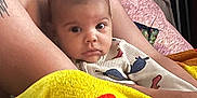 Deyvian is registered to the contest to win money with this photo: adult, arms, baby, bedroom, blanket, chair, child, clothing, colorful, comfort, curious, face, indoor, looking, person, pillow, seated, skin, tattoo, warm
